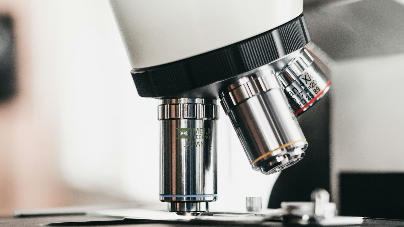 Une main réglant la mise au point d'un microscope