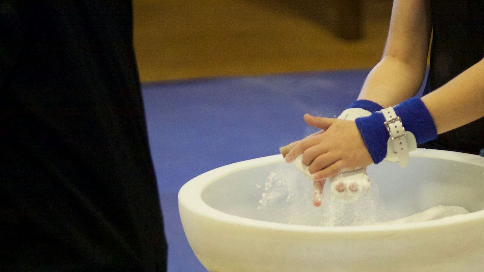 Les mains d'une gymnaste couvertes de magnésie avant de passer aux agrès