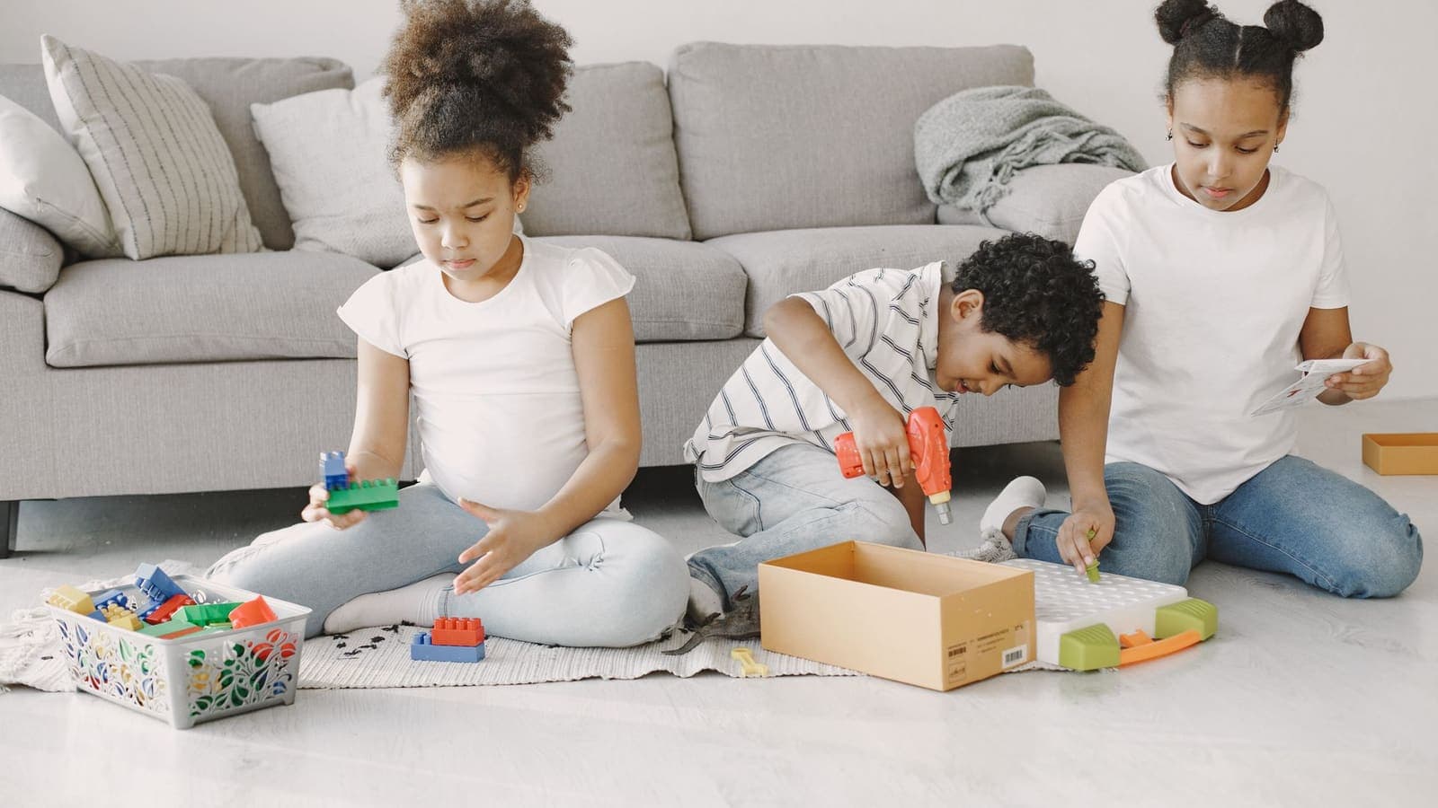 Plusieurs enfants jouant ensemble avec des jouets sur le sol
