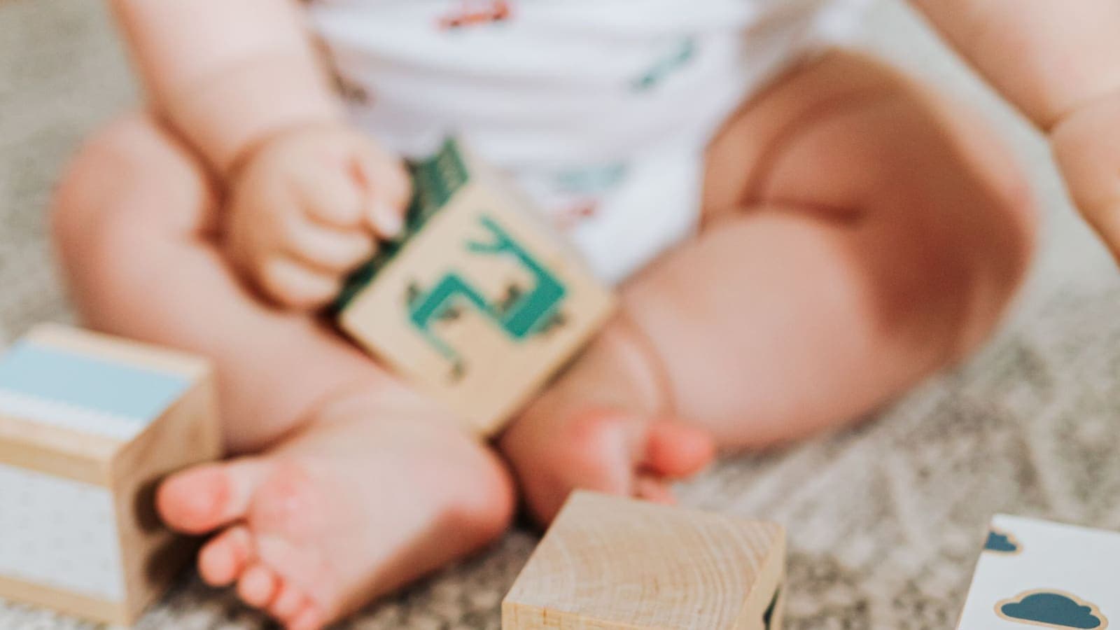 Des cubes et des jouets en bois posés sur un tapis
